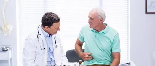 Doctor talking with an older patient about pain after hernia mesh surgery