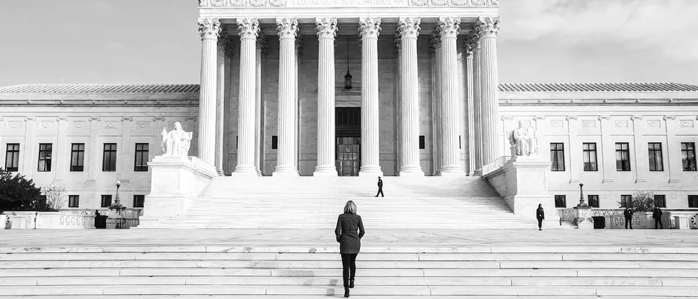 A lone person climbing the courthouse steps, representing a hernia mesh claim against a large manufacturer