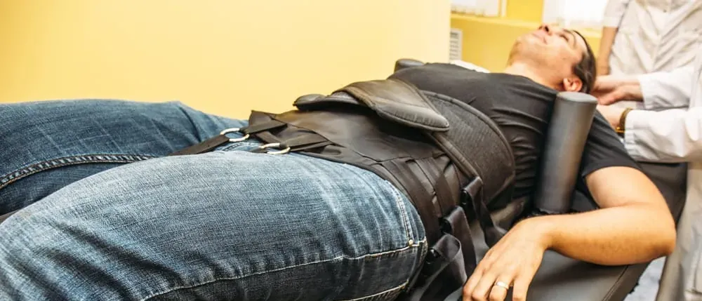 Man lying on a therapy table during treatment for hernia mesh complications